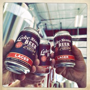 Cans of Lake State Beer's Lake State Lager being raised in cheers