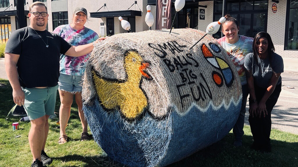 Crew from Socibowl by Pigeon Hill and the Hay Bale they decorated for Muskegon's hay bale competition.