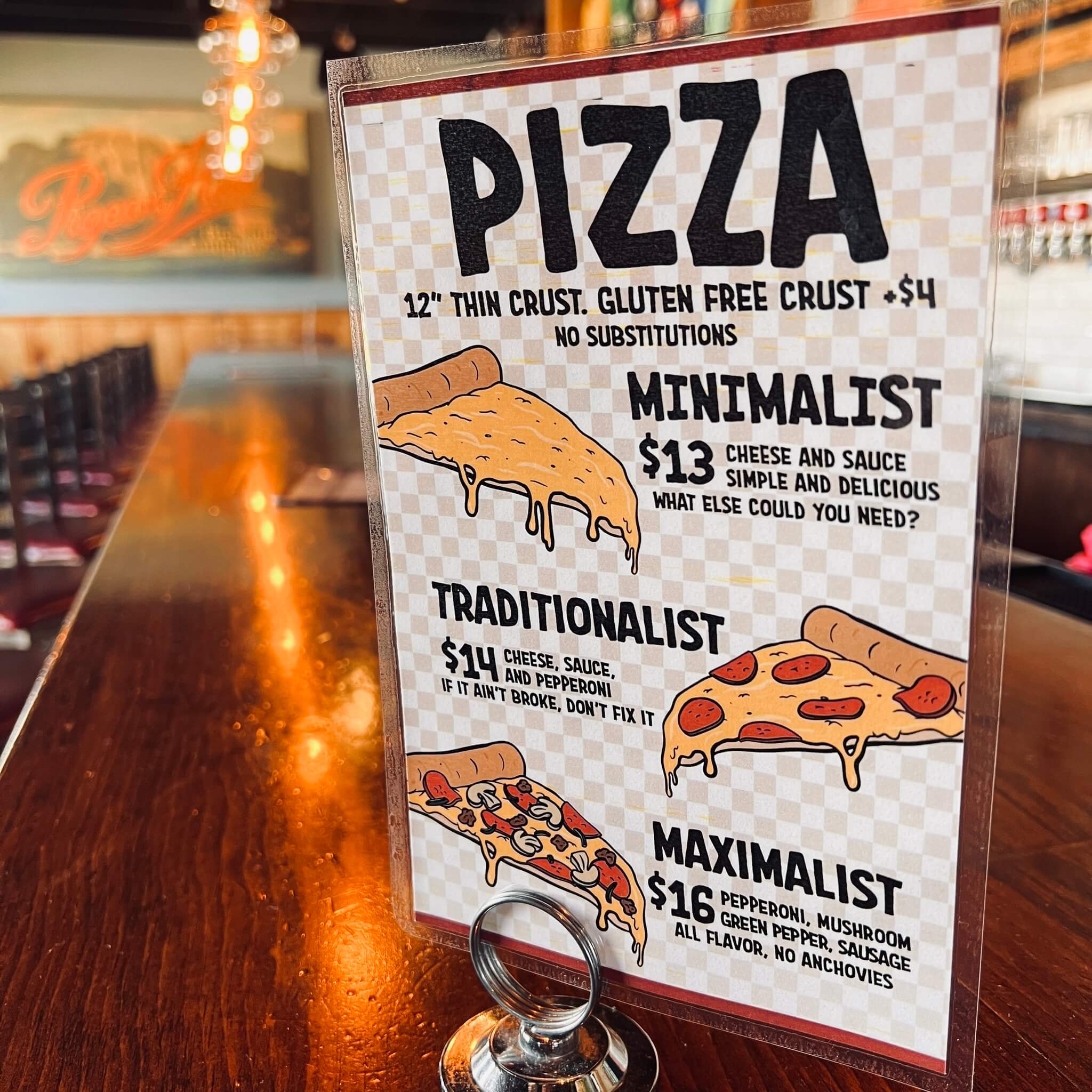 Menu for pizza on the bar at the Brewer's Lounge with beer taps in background.