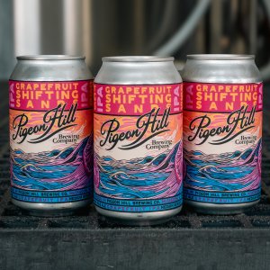 Three cans of Grapefruit Shifting Sands sitting inside of Pigeon Hill's Brewery